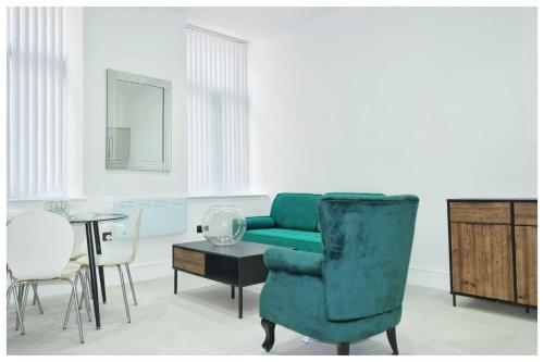 a living room with a green couch and a table at The Grandeur Mill in Bradford