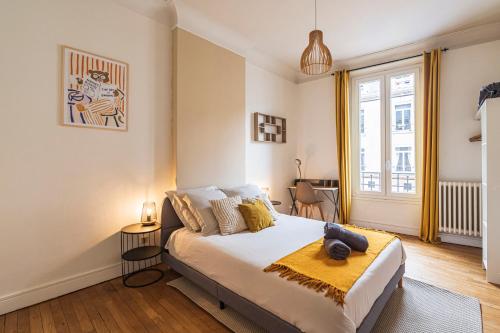 une chambre avec un lit avec une couverture jaune dessus dans l'établissement L'haussmannien - Spacieux 4 chambres - Centre - Gare, à Reims
