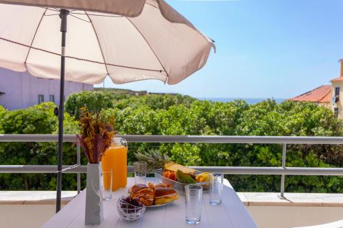 a table with a plate of food and an umbrella at Close to the sea, to Lisbon and to your heart in Silveira