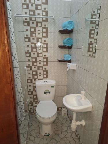 a small bathroom with a toilet and a sink at ANNA APARTMENTS MTWAPA in Mtwapa