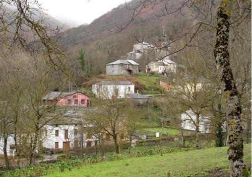 un grupo de casas en una colina con árboles en Casa Do Ferreiro - La Fragua, en Las Herrerías