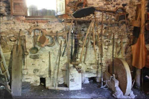 a wall with a bunch of utensils in a room at Casa Do Ferreiro - La Fragua in Las Herrerías