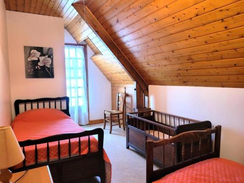 a bedroom with two beds and a wooden ceiling at Gîte de France La besse 2 épis - Gîte de France 6 personnes MAE-9144 in Louignac