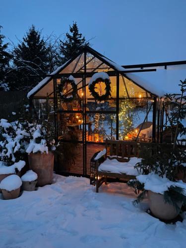 a greenhouse in the snow with lights in it at OrchardHouse Farmhouse, wellness in Chrast