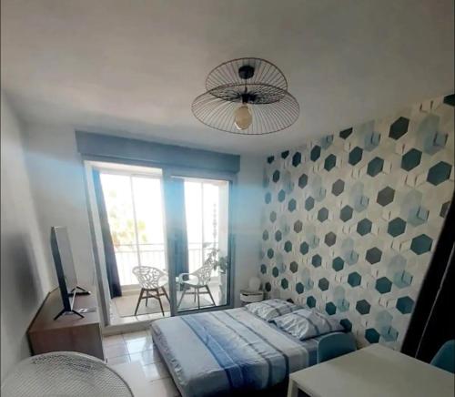 een slaapkamer met een blauw bed en een groot raam bij Appart A l'abordage Sète, Gare, parking in Sète