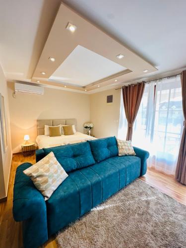 a living room with a blue couch in front of a bed at Villa Blanca in Risan