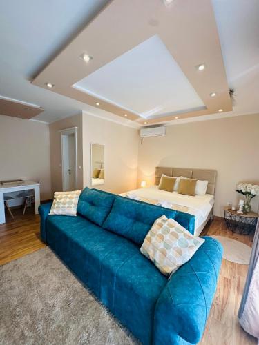 a living room with a blue couch and a bed at Villa Blanca in Risan
