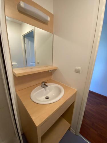 a bathroom with a sink and a mirror at Maisonnette dans village vacances canapé convertible , chambre 1 lit et mezzanine ,draps en plus in Cassen