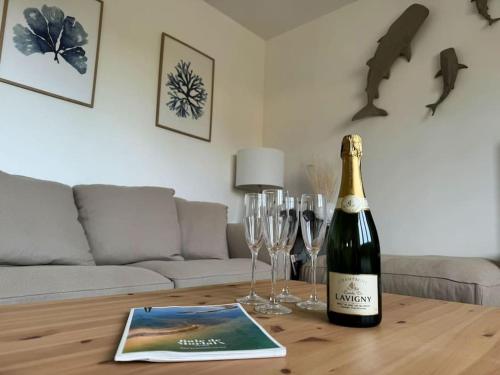 une bouteille de champagne et des verres à vin sur une table en bois dans l'établissement Ty Cléo - Maison Familiale proche bourg et plage, à Plougasnou