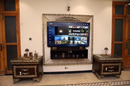 a large mirror with a tv in a room at Areej heights in Abbottabad