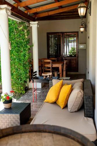 a living room with a couch on a patio at Camderest House in Graaff-Reinet