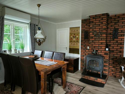 a dining room with a wooden table and a fireplace at Hytte ved Vråvatnet i Vrådal in Vradal