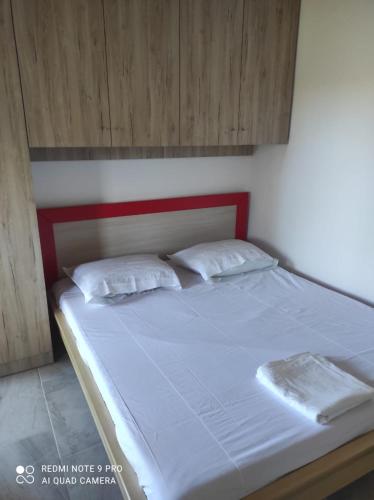 a bed with white sheets and pillows in a room at Portokallja Guest House Radhime in Vlorë
