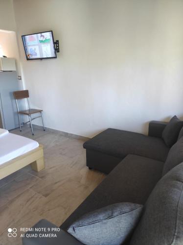 a living room with a couch and a tv at Portokallja Guest House Radhime in Vlorë