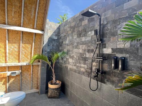 a bathroom with a shower with a plant in it at MoonBag Bungalows in Gili Air