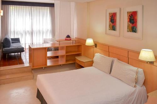 a bedroom with a bed and a desk and a chair at Edificio Corrientes 1856 in Buenos Aires