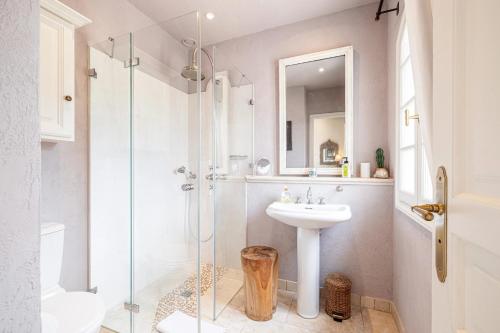 ein Badezimmer mit Waschbecken und Glasdusche in der Unterkunft Mas provencal luxueux vue mer in Mougins