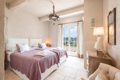 ein Schlafzimmer mit zwei Betten und einem Fenster in der Unterkunft Mas provencal luxueux vue mer in Mougins