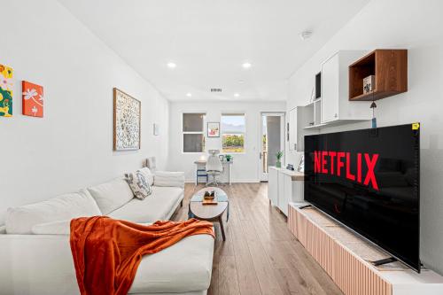 a white living room with a television and a couch at Luxurious Ontario Townhouse Ideal Family in Ontario