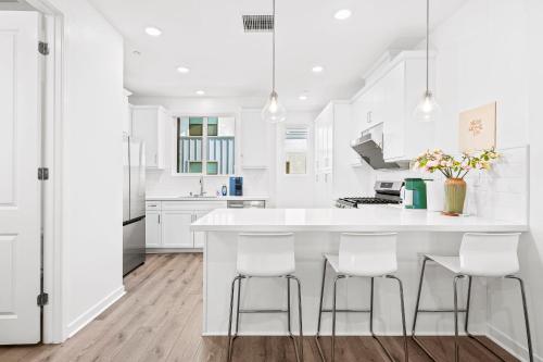 a white kitchen with white cabinets and white counter stools at Luxurious Ontario Townhouse Ideal Family in Ontario