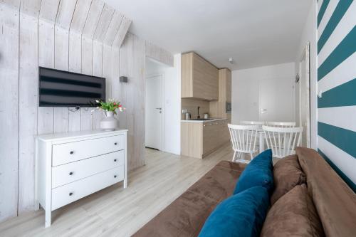 a living room with a couch and a tv at Apartamenty blisko morza Przy Wydmie in Darłówko