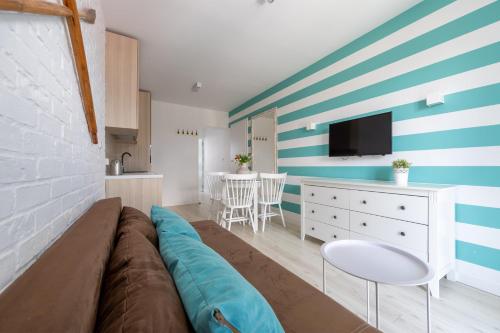 a living room with a couch and a kitchen at Apartamenty blisko morza Przy Wydmie in Darłówko