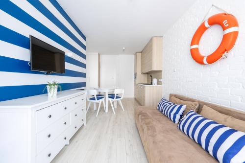 a living room with an orange and blue striped wall at Apartamenty blisko morza Przy Wydmie in Darłówko