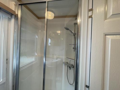 a bathroom with a shower and a sink at Letham Feus Caravan Park leven Fife Scotland in Leven-Fife