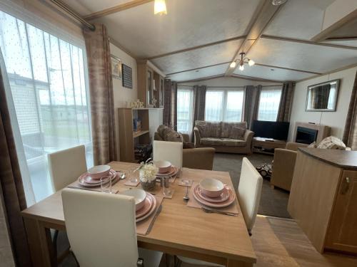 a dining room with a wooden table and chairs at Letham Feus Caravan Park leven Fife Scotland in Leven-Fife