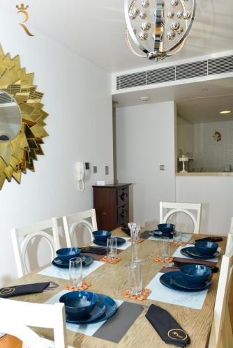 a dining room table with blue dishes on it at 2BR Stylish Escape - Mariana Luxe Al Raha in Abu Dhabi