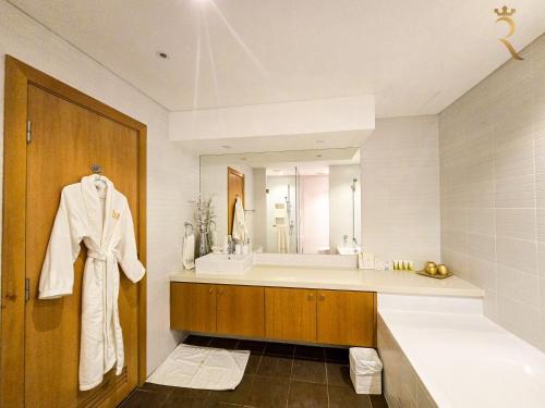 a bathroom with a sink and a bath tub at Al Raha Serenity - Spacious 2BR Getaway Near Yas Island & Al Raha Beach in Abu Dhabi