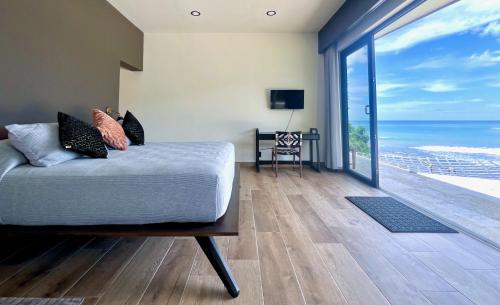 a bedroom with a bed and a view of the ocean at The Flamingo Experience in San Juan del Sur