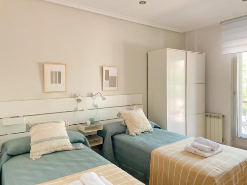 a bedroom with two beds and a cabinet at Apartamento Boza in Logroño