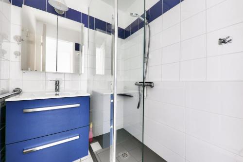 une salle de bain avec un lavabo bleu et une douche dans l'établissement Port du Crouesty Cap'Océan - maeva Home - Appartement 2 pièces 4 personnes vue sur le port - Sélection MAE-9421, à Arzon