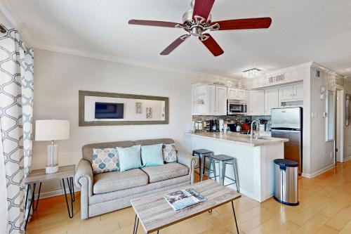 a living room with a couch and a ceiling fan at Victorian Condo #9227 in Galveston