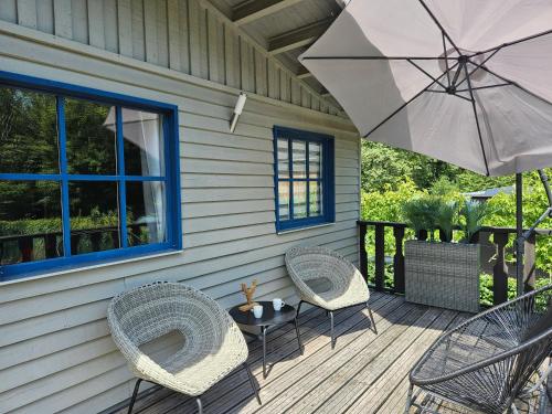 a patio with two chairs and a table and an umbrella at CHALET ARDENTARDENNE - Durbuy in Durbuy
