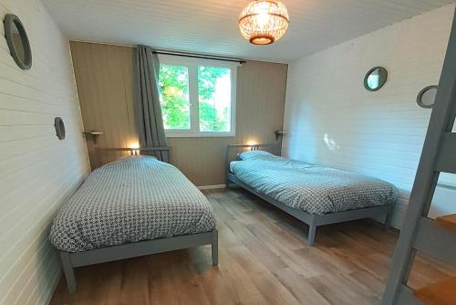 Un dormitorio con dos camas y una ventana. en CHALET ARDENTARDENNE - Durbuy, en Durbuy