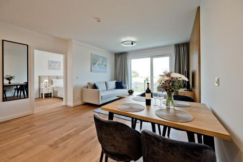 a living room with a dining room table with chairs at Aparthotel Anchoria BlueApart in Mechelinki