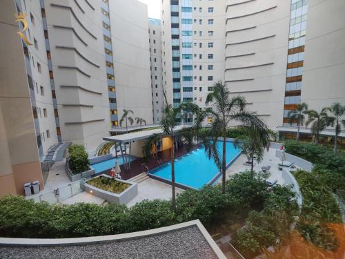 an overhead view of a pool with palm trees and buildings at 2BR Stylish Escape - Mariana Luxe Al Raha in Abu Dhabi