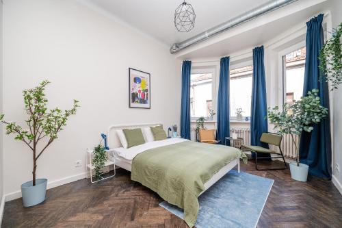 a bedroom with a large bed and blue curtains at Central Avenue Residence Kaunas in Kaunas