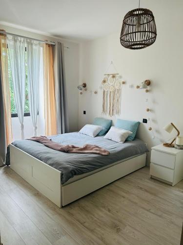 une chambre avec un grand lit dans une pièce dans l'établissement Charmante Maison de Village, à Saint-Laurent-des-Arbres