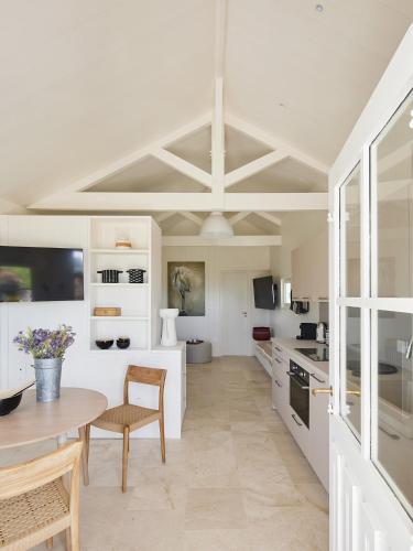 une cuisine avec des armoires blanches et une table et des chaises dans l'établissement MAISON SUR LA PLAGE avec VUE MER PANORAMIQUE, à Le Martray