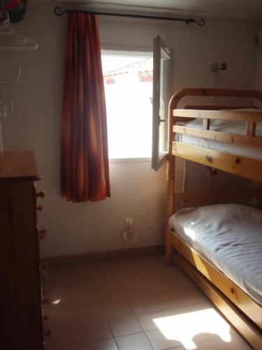 une chambre avec deux lits superposés et une fenêtre dans l'établissement Green Village, à La Grande Motte