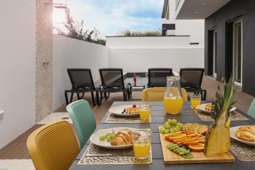 a table with plates of food and orange juice at Casa Branca in Óbidos