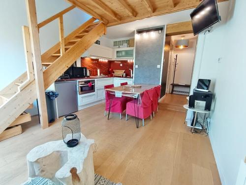 une cuisine avec une table et des chaises dans une pièce dans l'établissement Le nid de Juliette, T3 duplex, parking, cave, à Luchon