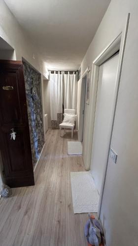 a room with a hallway with a door and a chair at B&B Baldì in Pertica Alta