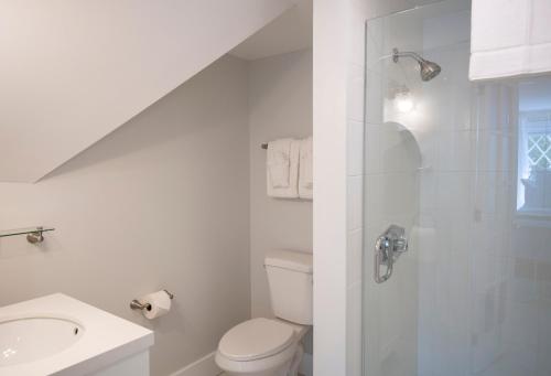 a white bathroom with a toilet and a sink at Cleftstone Inn in Bar Harbor