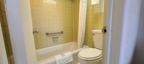 a bathroom with a toilet and a shower with yellow tiles at Mariner Inn And Suites in Kill Devil Hills