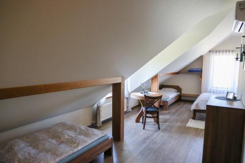 a room with two beds and a table in a room at Rīteņi in Ķesterciems
