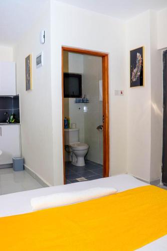 a bedroom with a bed and a bathroom with a toilet at Blessed homes in Nairobi